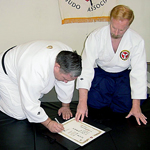 Dojocho Wilkes signing the Shubukan Certificate.
